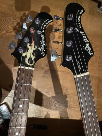 The two black headstocks of the two basses are quite unique. In later editions of this bass, the changed it to a variant with two tuning knobs on each side, rather than a big inline design like these have. This bass (same factory, but branded differently) was used in several Duran Duran videoclips.
