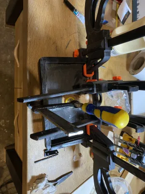 The paper case is modified after it is painted black. Hence the many glue clamps on it.